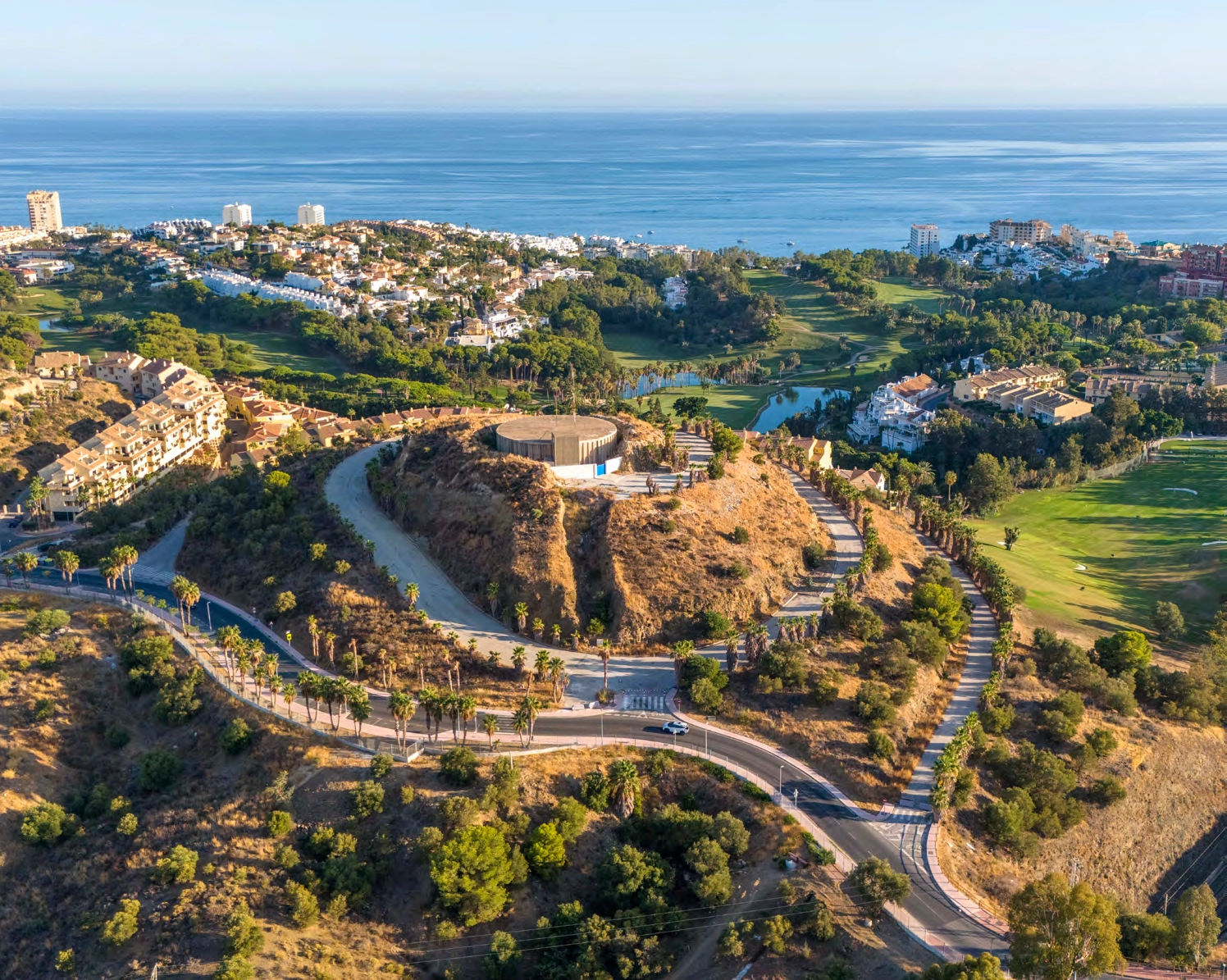 En flygbild som visar anläggningens privilegierade läge, inbäddat mellan bergen och havet.