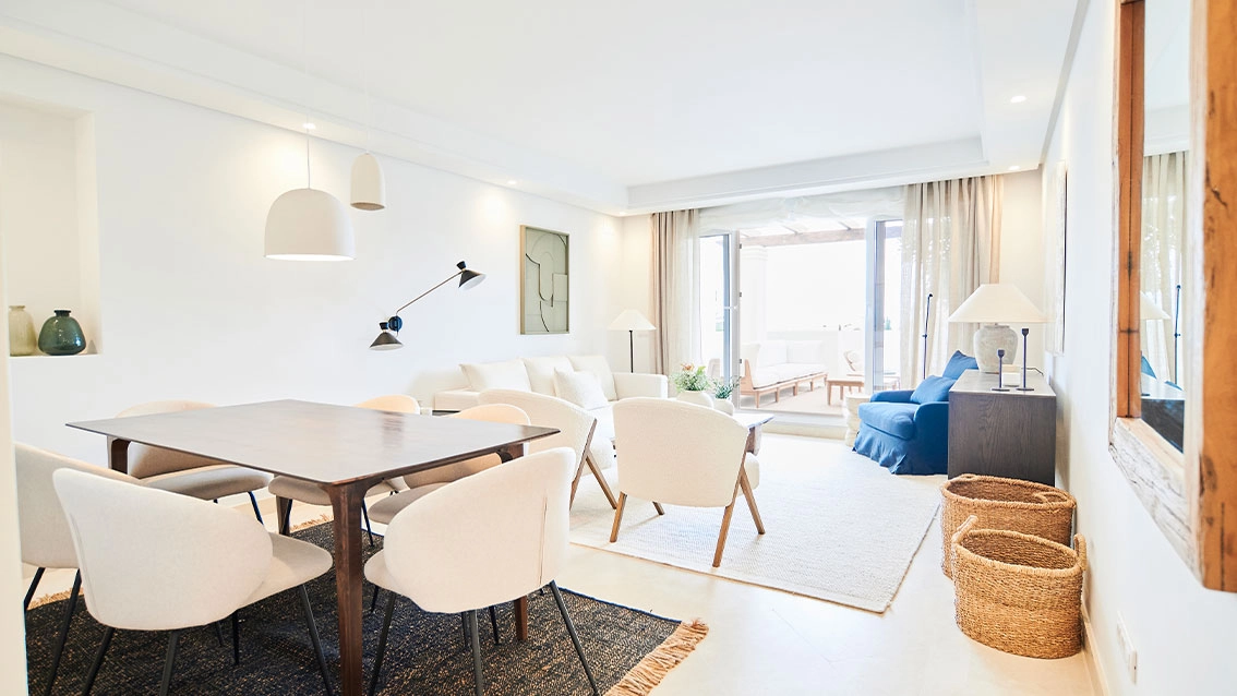 En ljus och rymlig vardagsrumsdel, designad för komfort och elegans, som sömlöst ansluter till utomhusmiljön.