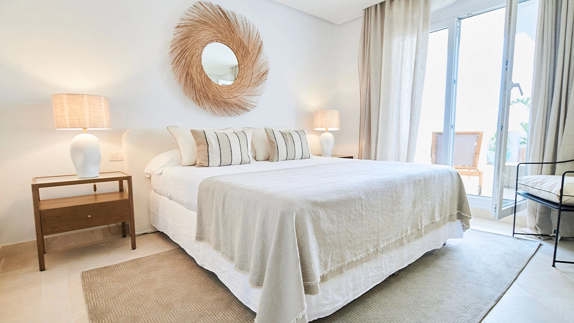 Det lugna master sovrummet, en fridfull tillflyktsort med naturligt ljus och direkt tillgång till terrassen.