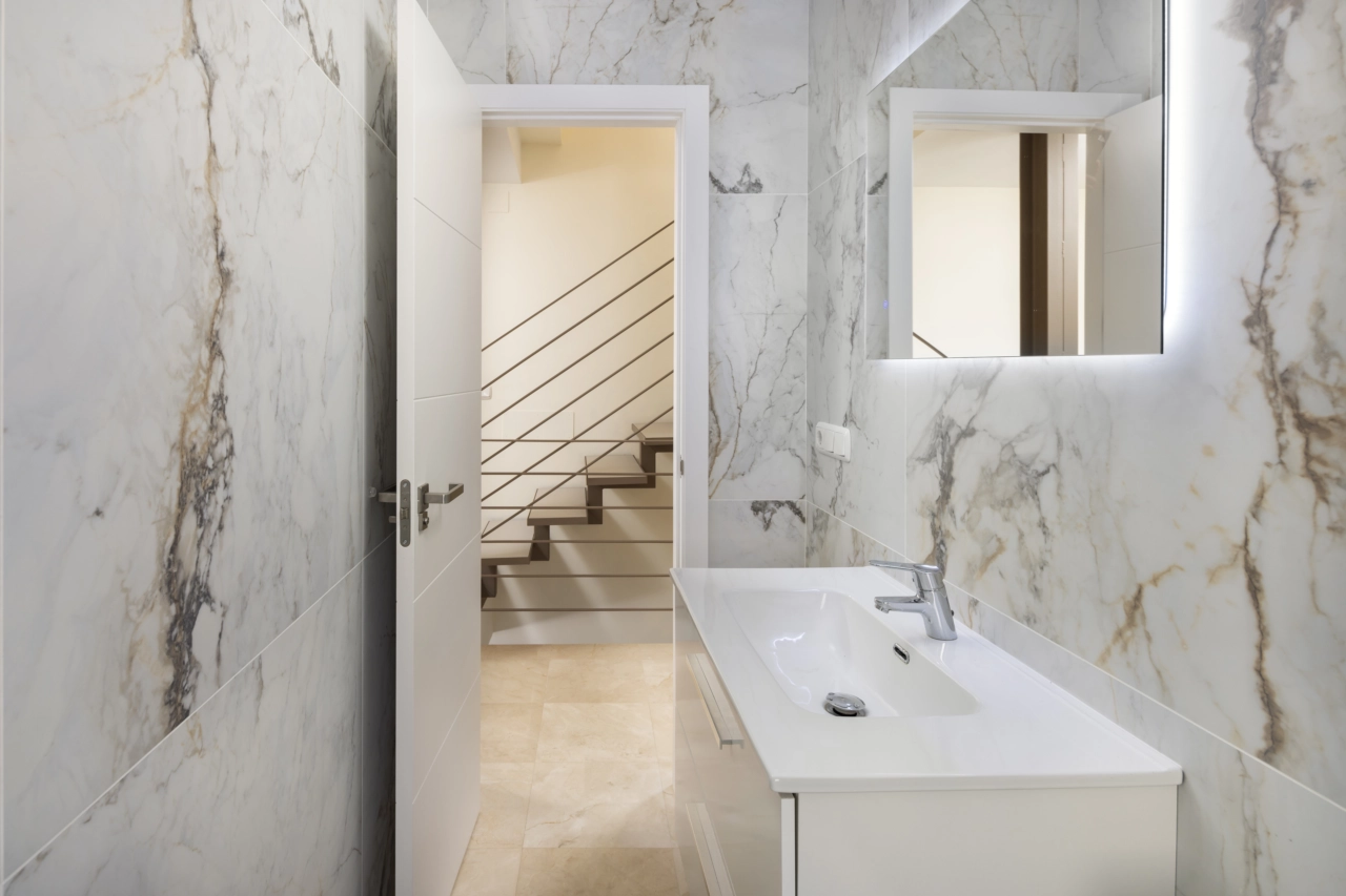 Ett modernt gästbadrum med stilrent kakel och kvalitetsinredning.