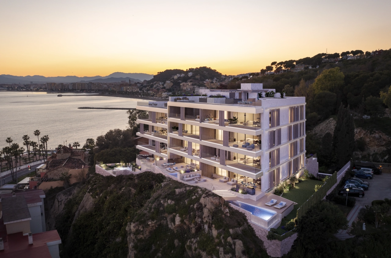 Projektets moderna arkitektur är vackert upplyst i skymningen, med utsikt över Malagas kustlinje.