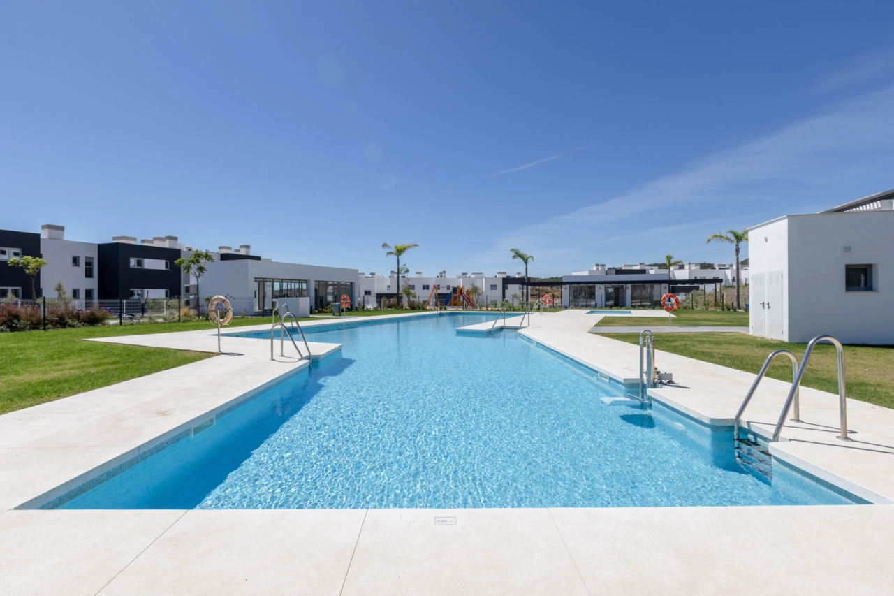 Den inbjudande poolen ligger i vackert anlagda trädgårdar för boende att njuta av.