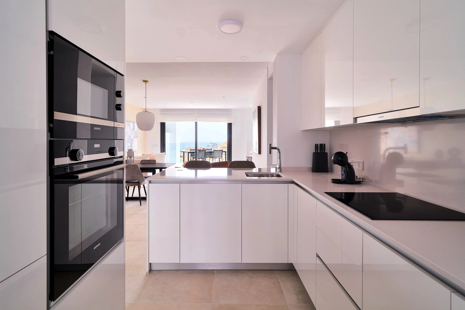 Ett modernt, fullt utrustat kök med frukostbar, designat för både funktionalitet och stil, som smidigt ansluter till vardagsrummet.