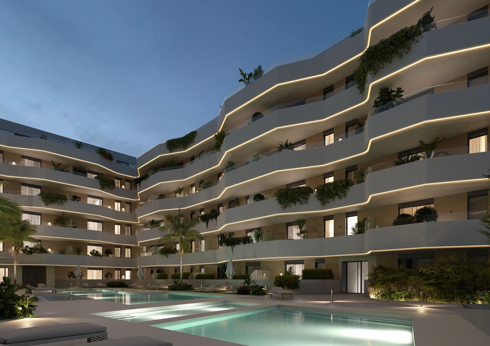 Gemensam pool och trädgårdar vackert upplysta på kvällen, vilket skapar en magisk atmosfär.