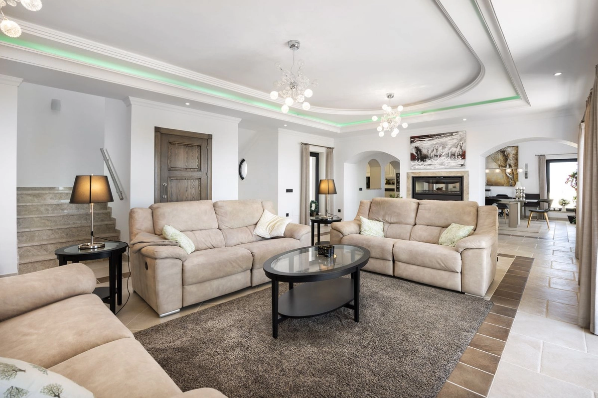 Det eleganta och rymliga vardagsrummet, fyllt med naturligt ljus, är designat för komfort och avkoppling.