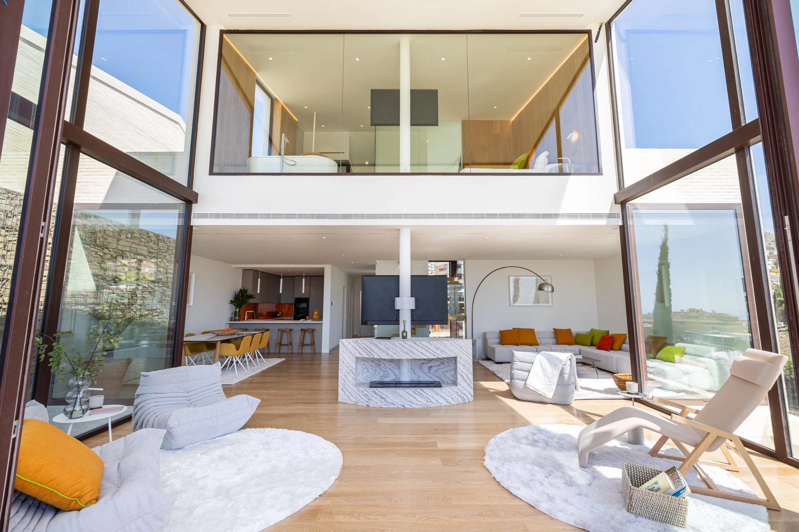 En vy in i det dubbelhöga vardagsrummet, där arkitektur och natur känns sammankopplade.