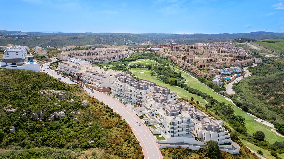 En flygvy över bostadsområdet, perfekt integrerat i Costa del Sols grönskande landskap med närliggande golfbanor.
