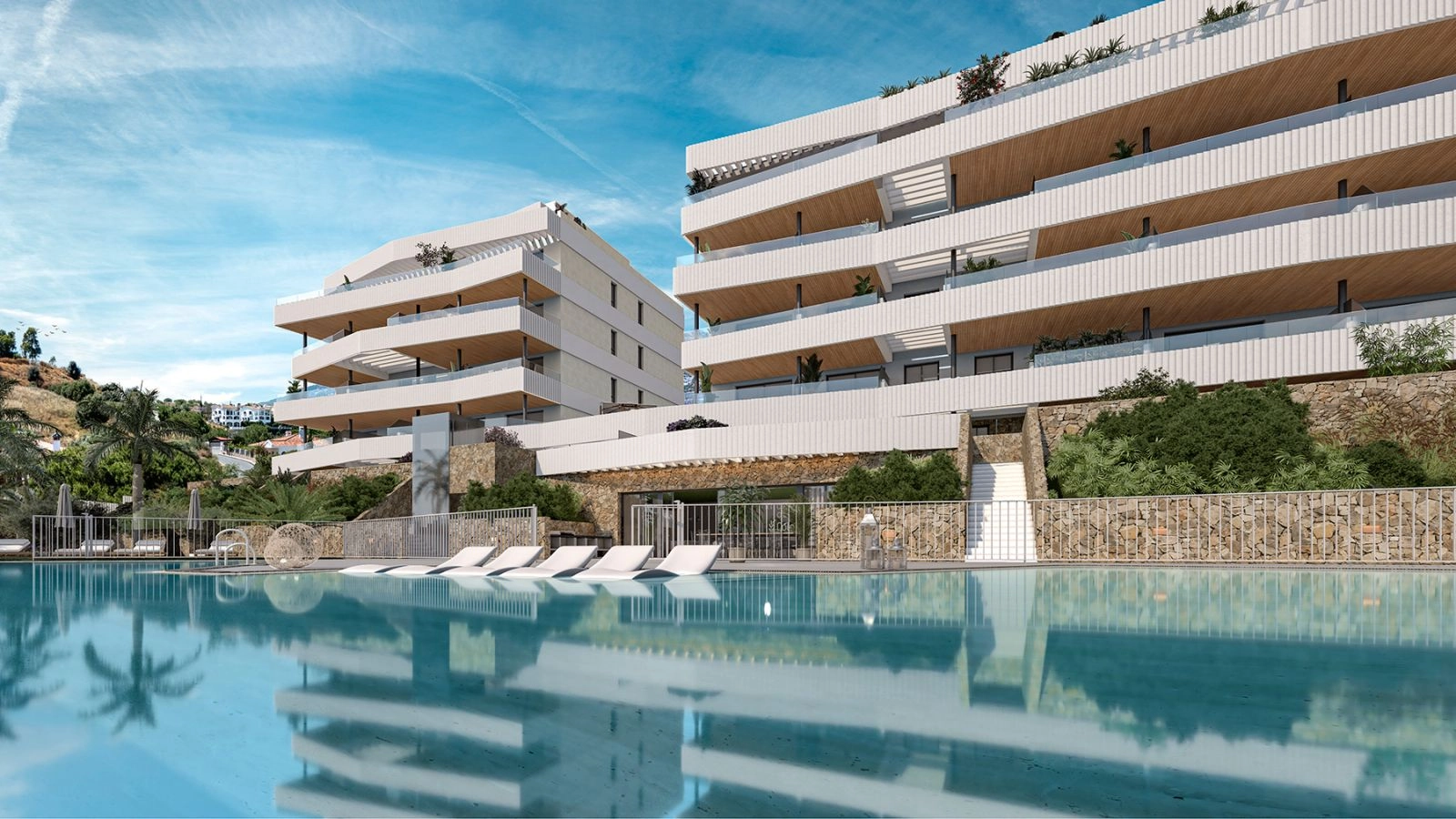 Den inbjudande gemensamma poolen och solplatsen, omgiven av modern arkitektur och lummig grönska.