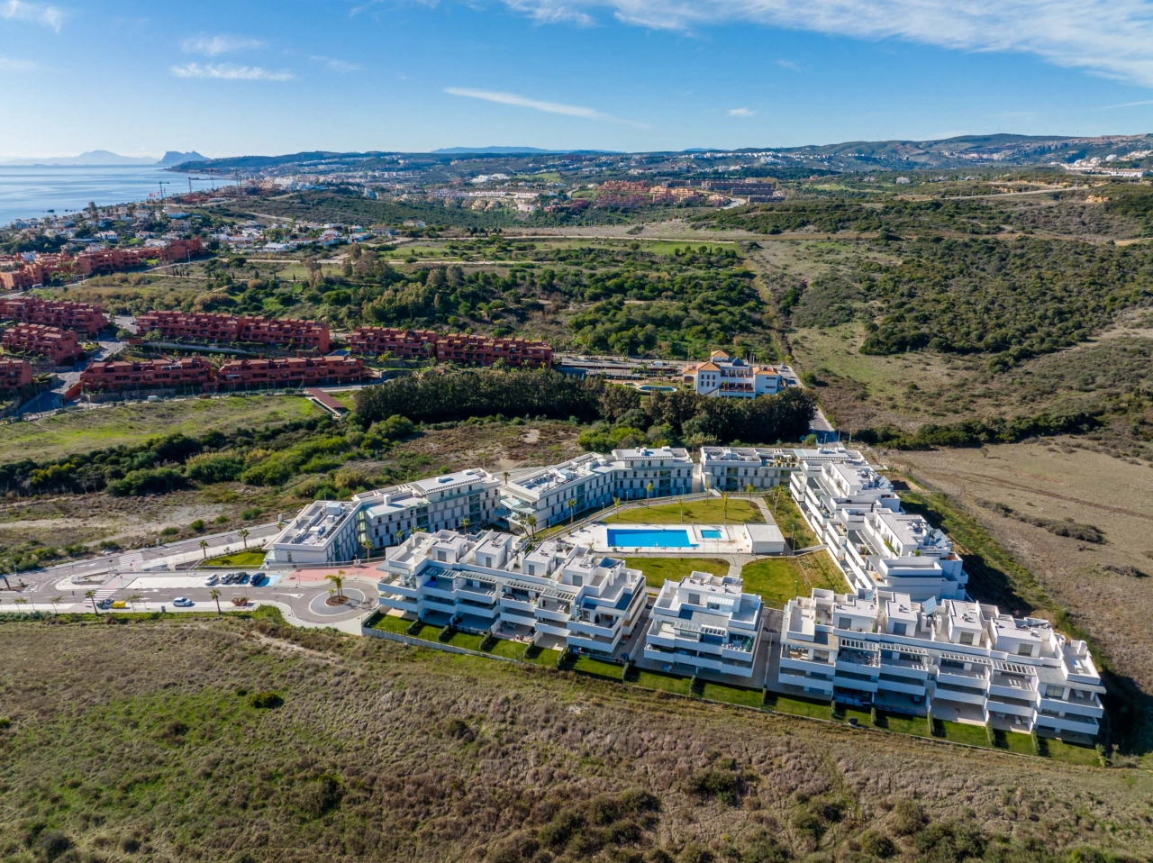 Den centrala poolen och solområdet, omgivet av anlagda trädgårdar, skapar en privat oas för de boende.