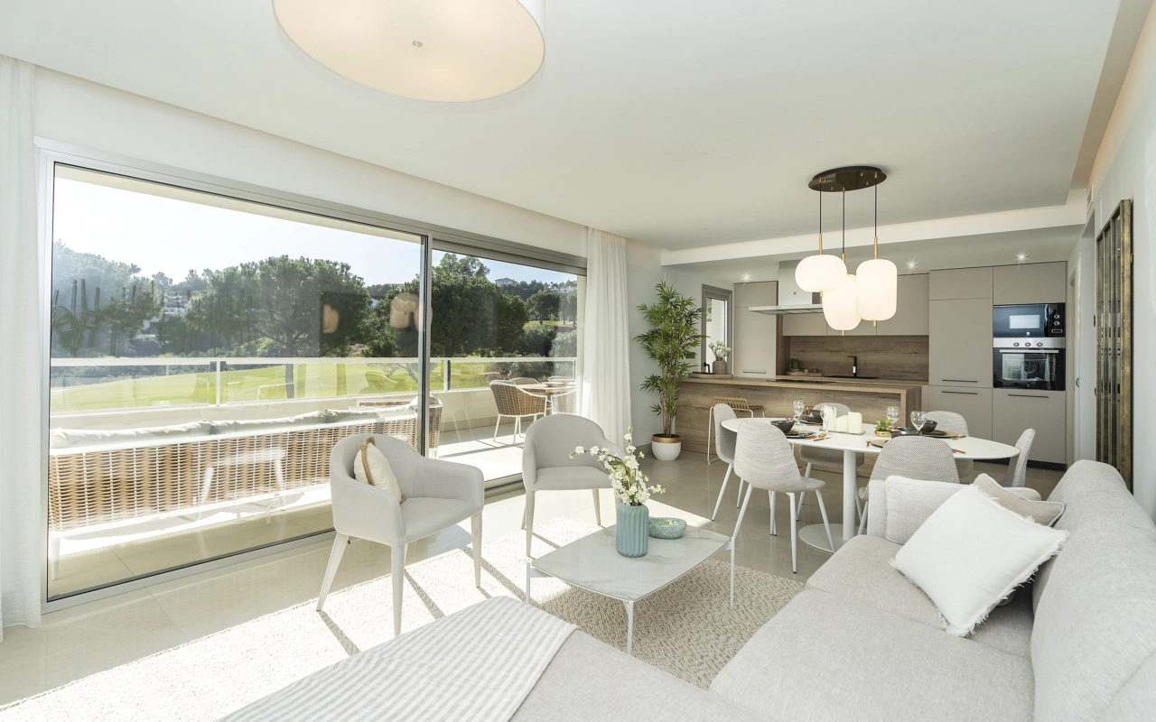 Solljus fyller det öppna vardagsrums- och matplatsområdet, vilket skapar en ljus och välkomnande yta för avkoppling och underhållning.